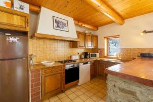 a kitchen with wooden cabinets and a stainless steel refrigerator at Chalet Les moulins in Bonneval-sur-Arc