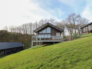 a house on top of a grassy hill at Bwncath in Welshpool