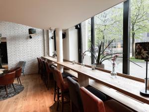 - un bar dans un restaurant avec des chaises et des fenêtres dans l'établissement Hotel Berliner Hof, à Kiel