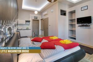 a large bed with red pillows on it in a room at Little Americas Hillside Apartments in Budapest