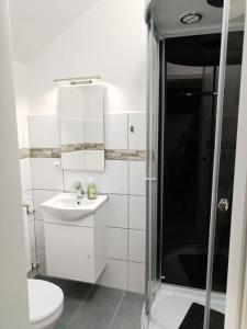 a white bathroom with a sink and a shower at Hotel am See Radevormwald in Radevormwald