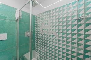 a bathroom with a green and white tiled wall at Hotel Miramare in Maiori