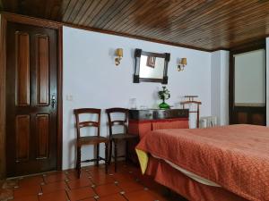 - une chambre avec un lit, une table et des chaises dans l'établissement Quinta da Mochada, 