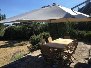 a table and chairs with an umbrella over it at A 2’ du port & du bourg maison spacieuse in La Trinité-sur-Mer