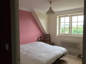 a bedroom with a white bed and a pink wall at A 2’ du port & du bourg maison spacieuse in La Trinité-sur-Mer