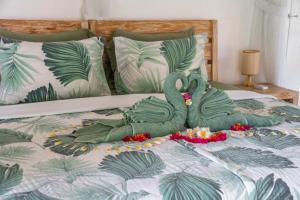 Tulus Hati Ubud Retreat في أوبود: بجعة خضراء محشوة ملقاة على السرير