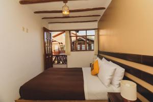 a bedroom with a bed and a window at Kutimuy Lodge in Urubamba