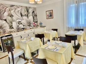 a restaurant with white tables and chairs and a mural at Villa Auditorium in Fortunago
