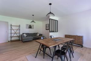a living room with a table and a couch at Appartement d'exception proche des commerces avec piscine in Biarritz