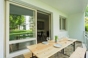 a wooden table with wine glasses on a patio at Appartement d'exception proche des commerces avec piscine in Biarritz