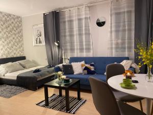 a living room with a blue couch and a table at BROWARNA apartamenty in Elblag