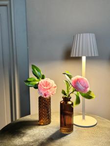 three vases with flowers on a table next to a lamp at Podere Gattabigia in Lastra a Signa