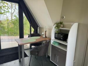 een kleine tafel en stoelen in een tiny house bij Hotelhuisjes Medemblik in Wieringerwerf