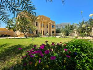 a house with pink flowers in front of it at Private Room Villa Dubai in Dubai