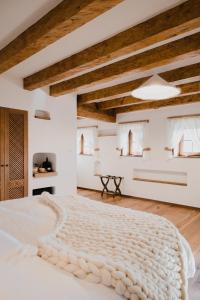 a bedroom with a large white bed with wooden ceilings at MATCA Transylvanian Sanctuary in Şimon