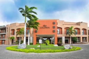 a building with a palm tree in front of it at Hotel Colonial Hermosillo in Hermosillo