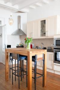 - une cuisine avec une table en bois agrémentée de quelques fleurs dans l'établissement La Découverte, appartement front de mer Mers, à Mers-les-Bains