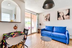 a living room with a blue couch and a table at Gruissan les MARINES II in Gruissan