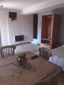 uma sala de estar com uma mesa de madeira e uma cama em Auberge des 7 ecluses em Rogny