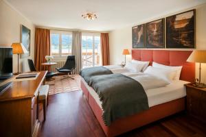 a hotel room with a large bed and a desk at Landhaus zu Appesbach in St. Wolfgang