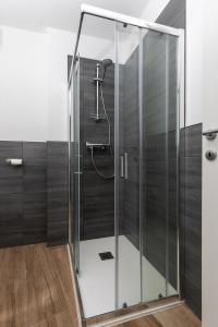 um chuveiro com uma caixa de vidro na casa de banho em Piazza del Lago Suites em Menaggio