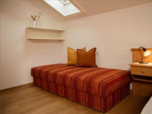 een slaapkamer met een bed met oranje lakens en een dakraam bij Ferienwohnung Rosenwirth - b45171 in Mittenwald