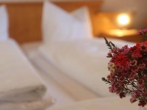 een boeket bloemen bovenop een bed bij Ferienwohnung Rosenwirth - b45171 in Mittenwald