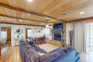 een woonkamer met een bank en een open haard bij Jewelbox Cottage in Huddleston