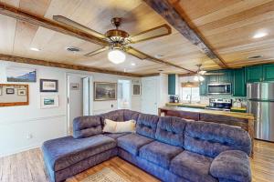 een woonkamer met een bank en een plafondventilator bij Jewelbox Cottage in Huddleston