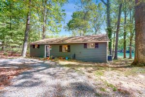 een klein groen huis midden in een bos bij Jewelbox Cottage in Huddleston