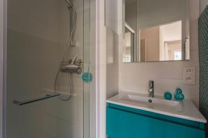 La salle de bains est pourvue d'une douche, d'un lavabo et d'un miroir. dans l'établissement Appartement d'exception proche des commerces avec piscine, à Biarritz