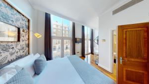 a bedroom with a bed and a large window at MSK Hotel 82 in London