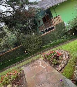 a house with a garden with flowers in the yard at Apartamento Aconchego Gramado in Gramado