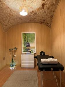 CASA RURAL VALLE SECRETO في Torremocha: غرفة بها كرسي وخزانة ذات لوحة