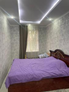 1 dormitorio con cama morada y ventana en Yunusabad 15, Tashkent, en Tashkent