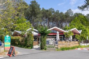 ein Restaurant am Straßenrand mit Bäumen in der Unterkunft Chalet cosy - vacances en famille in Léon