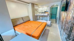 Kleines Zimmer mit orangefarbenem Bett. in der Unterkunft Appartamento Dolmaire - Affitti Brevi Italia in Sauze dʼOulx