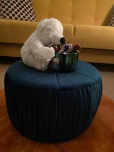 a white teddy bear sitting on top of an ottoman at BROWARNA apartamenty Tanie Spanie in Elblag