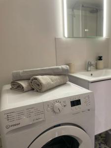 - un lave-linge avec des serviettes dans la salle de bains dans l'établissement Les appartements d'Albertine - Clémence, à Bourges