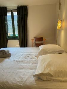 - une chambre avec un grand lit blanc et une fenêtre dans l'établissement Les appartements d'Albertine - Clémence, à Bourges