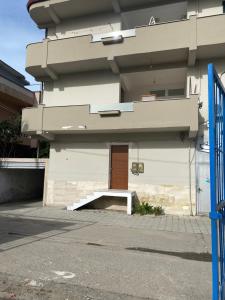 um edifício com uma porta e um banco à sua frente em Henri Apartaments em Durrës