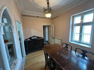 a dining room with a wooden table and a chandelier at Old town apartment next to sea Constanta in Constanţa