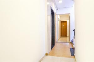 a hallway with white walls and a brown door at FabHotel Saffron Inn I in Pune