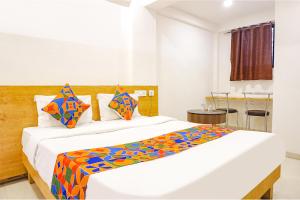 a bedroom with two beds with colorful pillows at FabHotel Saffron Inn I in Pune