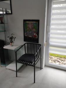 una silla y una mesa en una habitación con ventana en Ferienwohnung in Thermalbadnähe, en Bad Saulgau