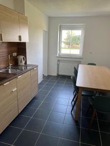 a kitchen with a sink and a table with chairs at Ferienglück am Spielplatz in Günzburg