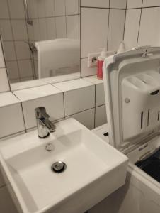 y baño con lavabo blanco y espejo. en Ferienwohnung in Thermalbadnähe, en Bad Saulgau