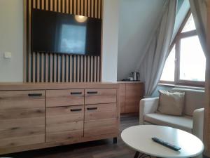 a living room with a dresser with a flat screen tv at Walkowy Dwor in Zakopane