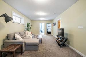 - un salon avec un canapé et une télévision dans l'établissement Large Modern style home with 5 Bedrooms Sleeps 12, à Edmonton