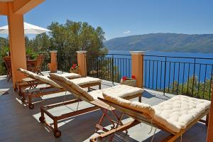 a group of lounge chairs and tables on a balcony at Lefki Sea View, Ithaca in Lefki